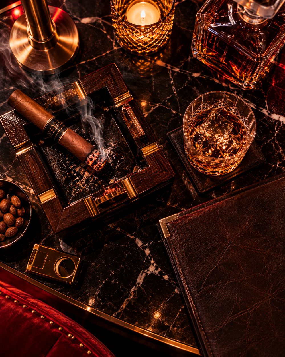 Premium cigars on a marble table beside a glass of whiskey