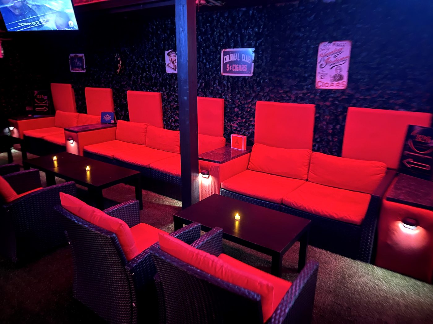 Seating area with cigar posters on the dark wall